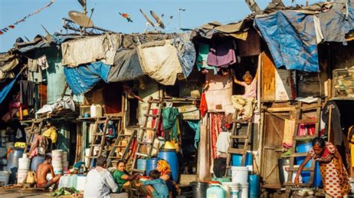 How are slums being improved?